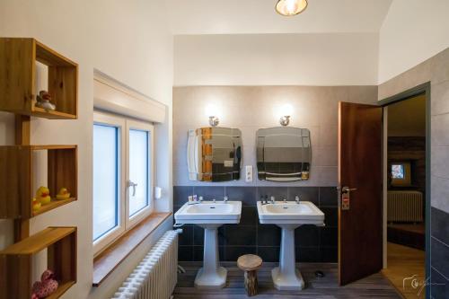 a bathroom with two sinks and two mirrors at Maison Castor in Vresse-sur-Semois