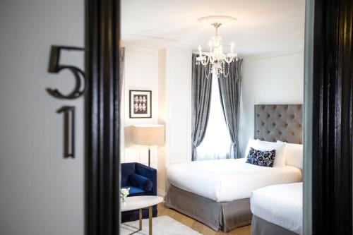 a bedroom with a bed and a chandelier at The Culver Hotel in Los Angeles