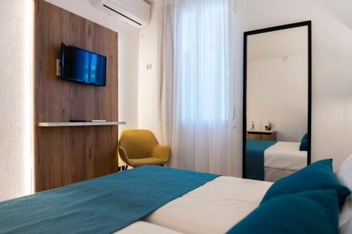 Una cama o camas en una habitación de Alfons Hotel