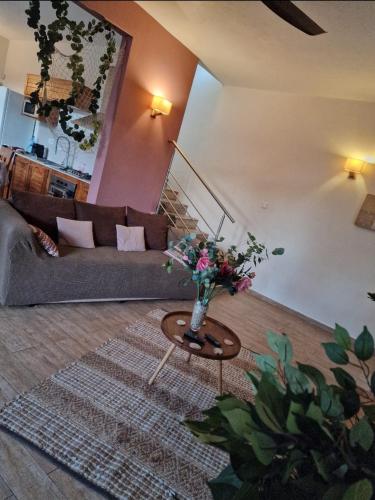 a living room with a couch and a table with flowers at Villa centre Grand Baie in Grand Baie