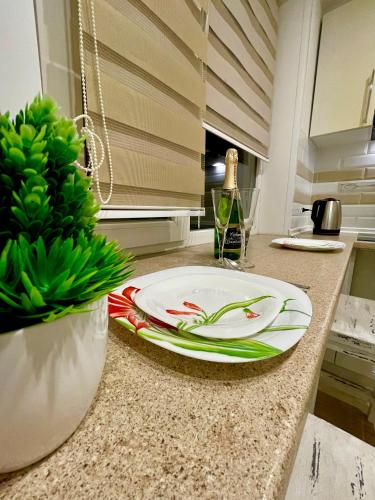a plate on a kitchen counter with a bottle of wine at Роскошные апартаменты в центре in Temirtaū