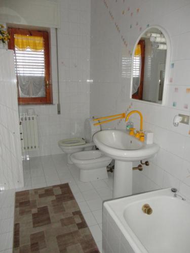 a white bathroom with a sink and a toilet at Casa delle Pomelie - Taormina & Etna Panoramic Views in Riposto
