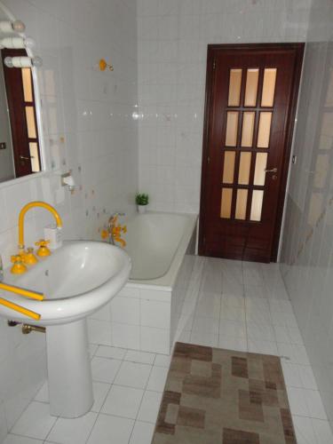 a white bathroom with a tub and a sink and a bath tub at Casa delle Pomelie - Taormina & Etna Panoramic Views in Riposto