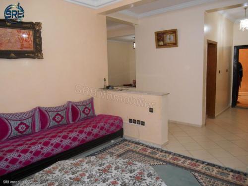 een woonkamer met een rode bank in een kamer bij salamappart in Agadir