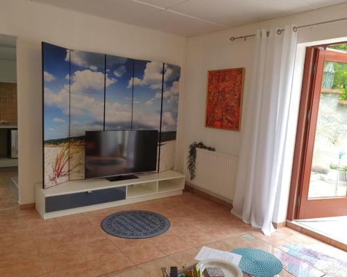 un salon avec une télévision à écran plat sur un mur dans l'établissement Lägenhet Thujan, Solrosen i Simrishamn-Österlen, à Simrishamn