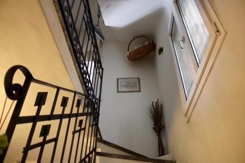 a hallway with a spiral staircase with a basket on the wall at 1912 - Wooden Room - old town in Locarno