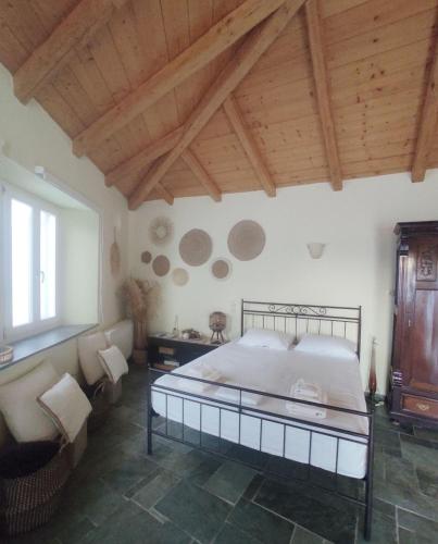 een slaapkamer met een groot bed en een houten plafond bij House Moschα in Ándros