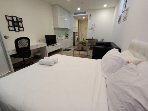 a bedroom with a white bed and a living room at City Home Suites Kuala Lumpur City Centre in Kuala Lumpur