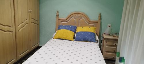 ein Schlafzimmer mit einem Bett mit zwei Kissen darauf in der Unterkunft Elche Holidays in Elche