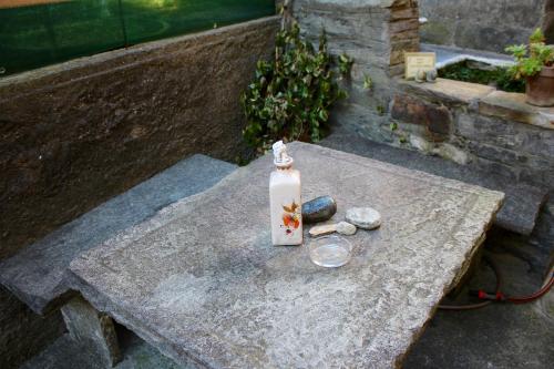 a bottle on a stone table with rocks on it at 1912 - Wooden Room - old town in Locarno
