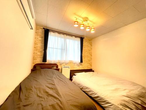 1 Schlafzimmer mit 2 Betten und einem Fenster in der Unterkunft Avidasion - Vacation STAY 13341 in Biei