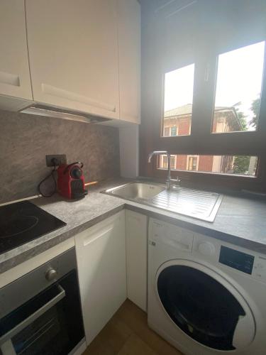 a kitchen with a sink and a washing machine at Bed&Coffee Milano in Milan
