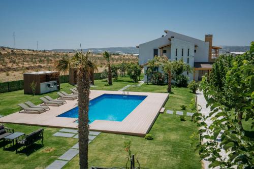 Villa con piscina frente a una casa en Ali Baba Ciftligi Boutique Hotel en Alacati