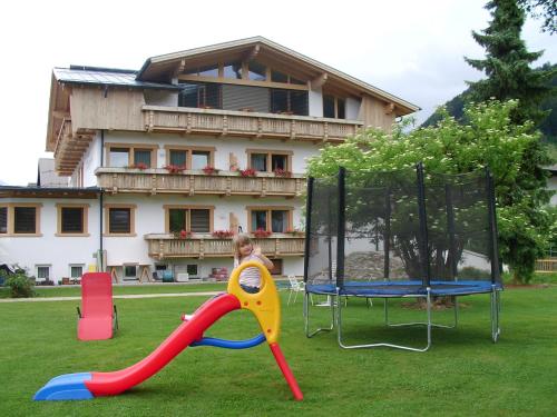 dziecko bawiące się na placu zabaw przed domem w obiekcie Haus Margreth w mieście Sillian