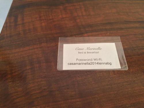 a white card sitting on a wooden table at Bed & Breakfast Casa Marinella in Lenna