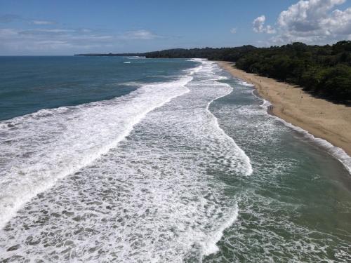 an aerial view of the shoreline of a beach at HOTEL, VILLAS y GLAMPINGS MYA -PUERTO VIEJO, Limon, CR in Puerto Viejo