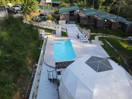 an overhead view of a pool with a table and umbrella at HOTEL, VILLAS y GLAMPINGS MYA -PUERTO VIEJO, Limon, CR in Puerto Viejo