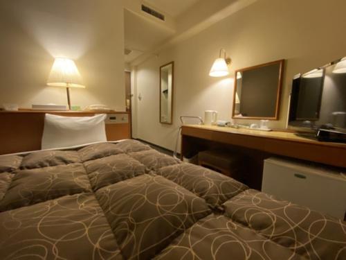 a hotel room with a bed and a desk with a computer at Az Inn Fukui - Vacation STAY 65924v in Fukui