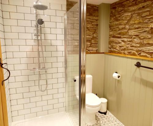 y baño con ducha y aseo. en Hay Barn, Penrheol Farm, Unique Barn Conversion, en Builth Wells