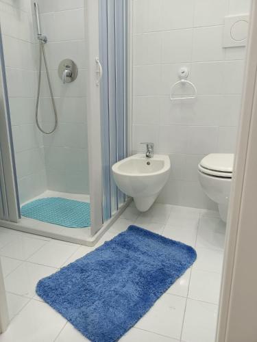 baño con ducha y alfombra azul en Anna’s room en Sorrento
