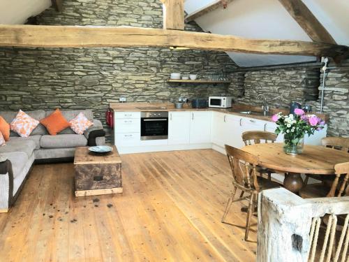 uma cozinha e sala de estar com um sofá e uma mesa em Hay Barn, Penrheol Farm, Unique Barn Conversion em Builth Wells