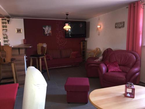 a living room with red furniture and a table at fun4all-holidayhome in Medebach