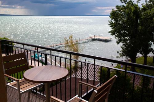 a balcony with a table and chairs and the ocean at Tópart Hotel in Balatonvilágos