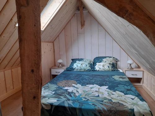 ein Schlafzimmer mit einem Bett im Dachgeschoss in der Unterkunft Le Séverin : Appartement lumineux et chaleureux in Crécy-en-Ponthieu