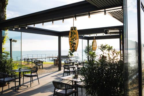 a restaurant with tables and chairs and a view of the ocean at Tópart Hotel in Balatonvilágos