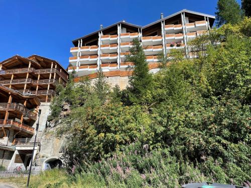 an apartment building on a hill with trees at Haus Oasis in Zermatt