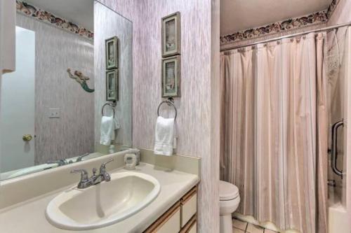 a bathroom with a sink and a toilet and a mirror at Resort gem w/ 2-bedrooms and easy walk to beach in Panama City Beach