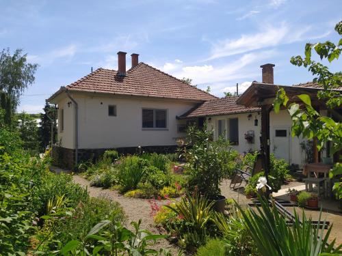 uma casa com um jardim em frente em Eperkert Vendégház em Parád