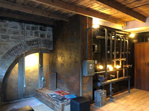 Cette chambre est dotée d'un mur en pierre et d'une cheminée. dans l'établissement APPARTEMENT style loft industrielle de 250m2, à Longwy