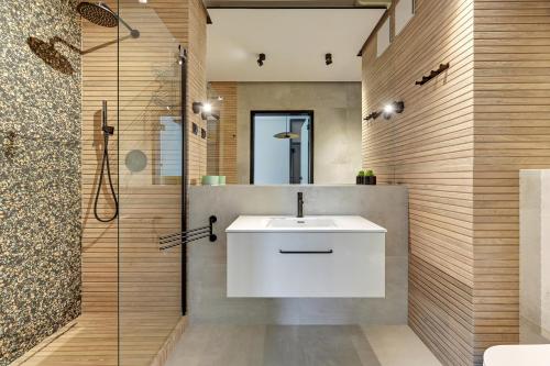 a bathroom with a white sink and a shower at Wave Apartments - Yacht Park 2 in Gdynia