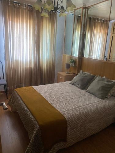 1 dormitorio con 1 cama grande y espejo en El apartamento de María Vut-47-31, en Tordesillas