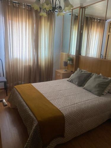 een slaapkamer met een groot bed en een spiegel bij El apartamento de María Vut-47-31 in Tordesillas