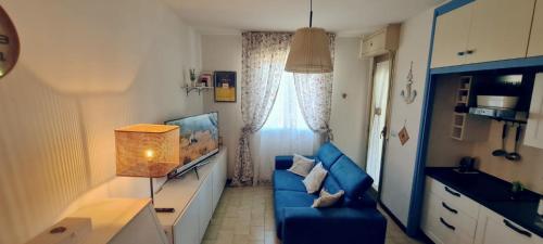 a living room with a blue couch and a window at Bali in Abruzzo in Silvi Marina