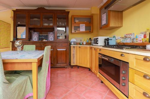 una cocina con armarios de madera y una mesa. en San Berillo house, en Catania