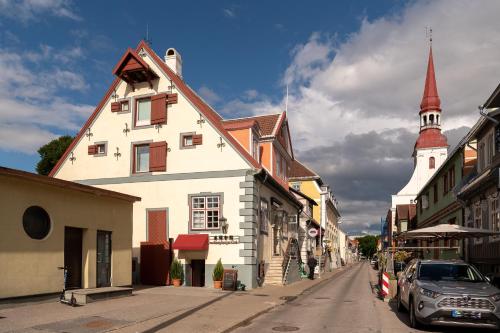 een straat met een wit gebouw en een kerk bij Tare apartment in Pärnu