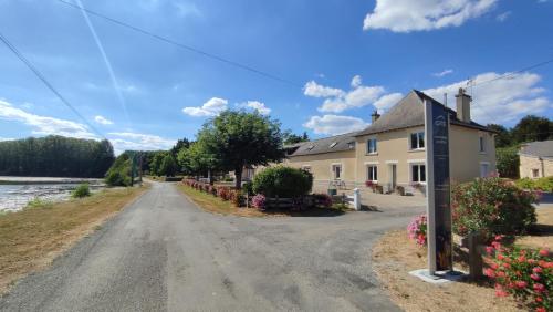 an empty road in front of a house with flowers at Chambre d'Hôtes - La Rigaudière in Le Theil-de-Bretagne