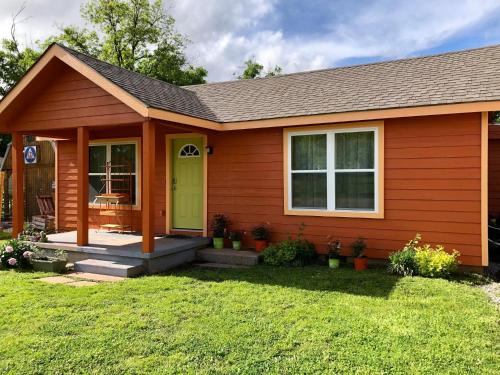a house with a green door and a yard at EZ 1 mile to Fort Sill! Pumpkin Cottage sleeps 9, grills, firepit, laundry in Lawton
