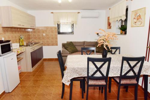 une cuisine et une salle à manger avec une table et des chaises dans l'établissement Apartman Bingo, à Josipdol