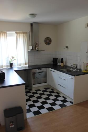 a kitchen with a black and white checkered floor at Ferienwohnung Zeitlos in Bad Bentheim