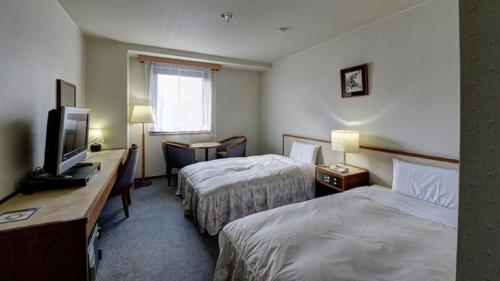 um quarto de hotel com duas camas e uma televisão em Hotel Fuyokaku - Vacation STAY 13411v em Fujiyoshida