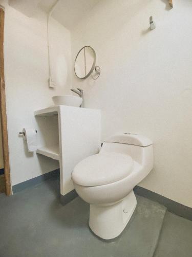 a bathroom with a white toilet and a mirror at Mamallena Beachside Rincon del Mar in Rincón