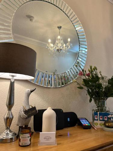 a mirror on top of a table with a lamp at Abbey House B & B in Penrith
