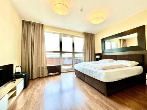 a bedroom with a large bed and a large window at Balu Apartments in Prague