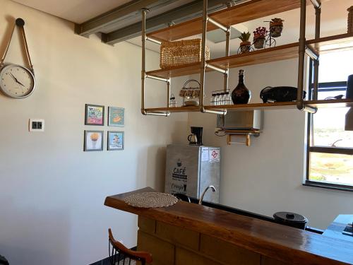 a kitchen with a counter and a clock on the wall at Apart Hotel Seg Total Lofts Encantadores in Mogi-Guaçu