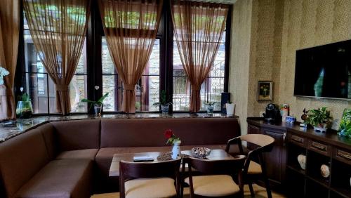 un soggiorno con divano, tavolo e sedie di Семеен Хотел Чардаците a Lovech