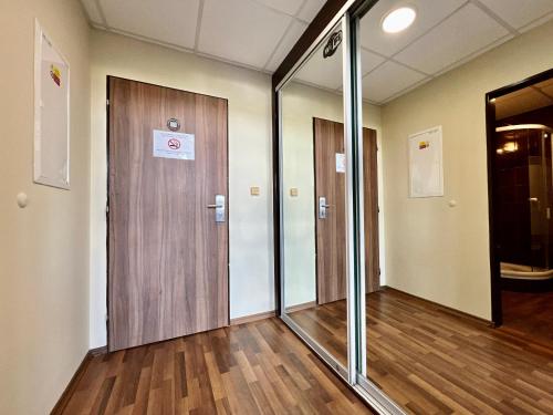 an empty room with glass doors and wooden floors at Balu Apartments in Prague